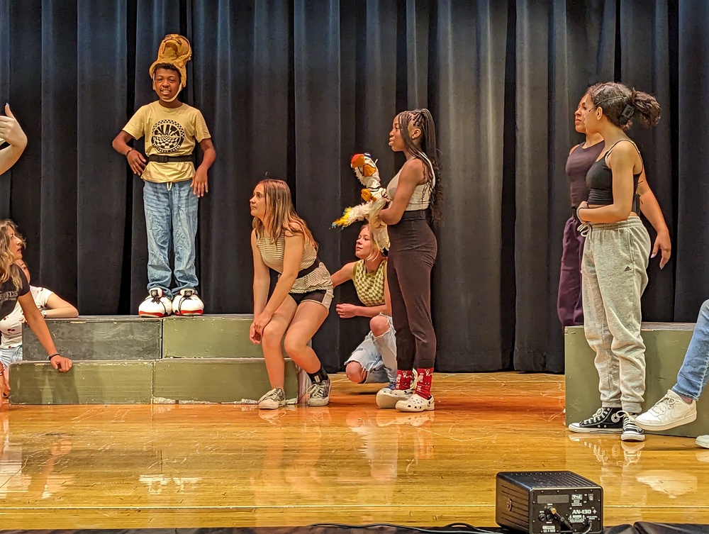 Cast members rehearsing on stage
