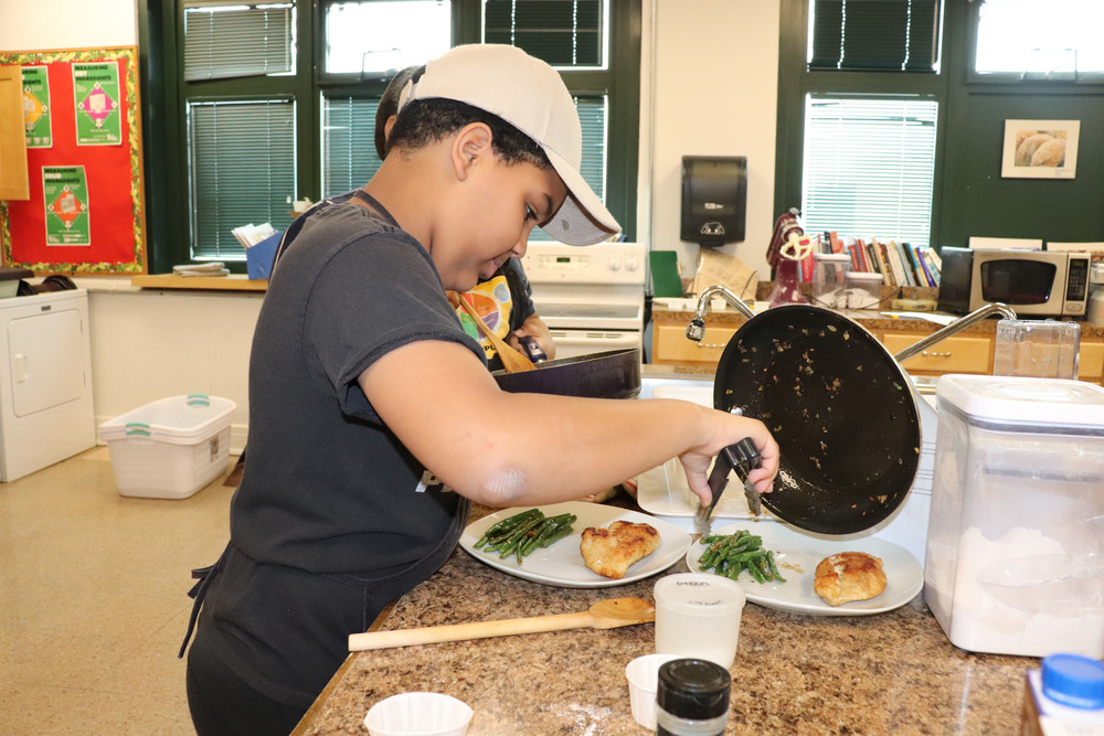Student plating food that he prepared.